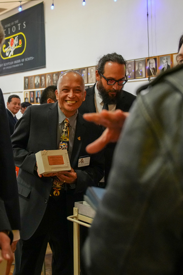 Roland Sanchez showing his award while waiting in buffet line